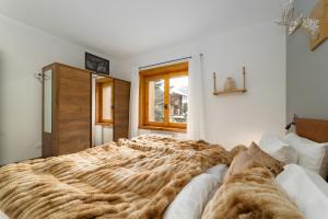 Cette chambre comprend un grand lit et une fenêtre. dans l'établissement Dany Lodge Livigno, à Livigno