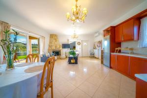 a kitchen and living room with a table and a dining room at Villa Lima Pool & Jacuzzi Chania in Vamos