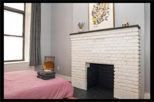a room with a white brick fireplace and a bed at 3BR Central Park in New York