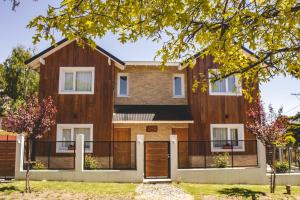 a wooden house with a gate and fence at Cabañas Los Manzanos in San Martín de los Andes