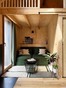 a living room with a green couch and a table at Bayda's Tiny House in Sprimont
