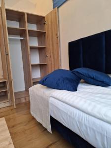 une chambre avec un lit avec un oreiller bleu dessus dans l'établissement Pokoje Gościnne Koral, à Miasteczko Śląskie