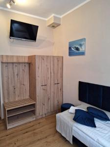 une chambre avec un lit et une télévision au mur dans l'établissement Pokoje Gościnne Koral, à Miasteczko Śląskie