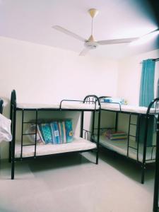 two bunk beds in a room with a ceiling fan at Ahjar hostel only ladies in Muscat