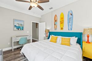 ein Schlafzimmer mit Bett, Schreibtisch und Surfbrettern an der Wand in der Unterkunft Laguna Matata by Book That Condo in Panama City Beach + 63 Fotos
