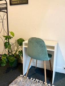una sedia verde seduta di fronte a una scrivania di Chambre 4, calme, 1 station de PARIS a Maisons-Alfort