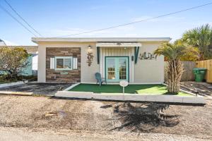 ein kleines Haus mit Rasen davor in der Unterkunft Laguna Matata by Book That Condo in Panama City Beach