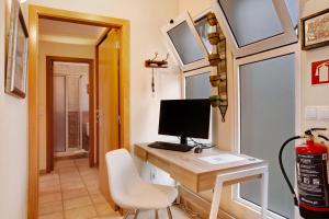 ein Computer auf einem Schreibtisch in einem winzigen Haus in der Unterkunft Energia Dourada - Porto Santo in Porto Santo