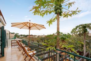 einen Balkon mit Stühlen und einem Sonnenschirm in der Unterkunft Energia Dourada - Porto Santo in Porto Santo