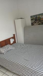 1 dormitorio con 1 cama y nevera en Kitnet en Tramandaí