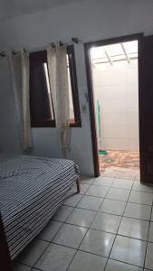 Schlafzimmer mit einem Bett, einem Fenster und einer Tür in der Unterkunft Kitnet in Tramandaí