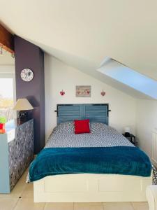 um quarto com uma cama grande e uma almofada vermelha em Gîte Rose des Vignes em Voegtlinshoffen