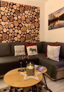 uma sala de estar com um sofá e uma mesa com copos de vinho em FeWo Fuchs Saig em Lenzkirch