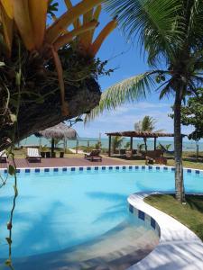 a swimming pool with a view of the ocean at Pousada Mayon in Cumuruxatiba