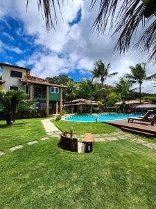 un patio con una casa y una piscina en Pousada Mayon, en Cumuruxatiba