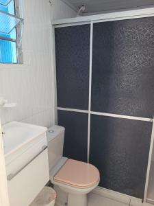 bagno bianco con servizi igienici e doccia di Pousada Cantinho Azul a Passo de Torres