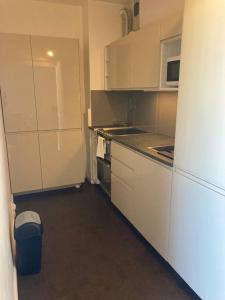 uma pequena cozinha com armários brancos e um frigorífico em Appartement 41m2 wifi, climatisé : La Grande Motte em La Grande-Motte