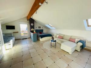 uma sala de estar com um sofá e uma cama em Gîte Rose des Vignes em Voegtlinshoffen