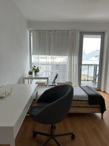 a bedroom with a desk and a chair in front of a window at Apartmán ERUDITO in Jihlava