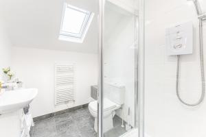 a white bathroom with a toilet and a shower at Luxury Stay - Parking, Close City Centre, Netflix & Disney, in Nottingham