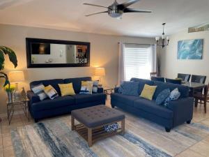 a living room with two blue couches and a table at Destin Miramar Walk To Beach Pet Friendly in Destin