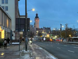 a city street with a clock tower in the distance at N8 ROOMS - by Leipzig Suites in Leipzig