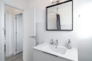 a white bathroom with a sink and a mirror at Marina Vista Paradise Casasol in Nerja