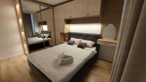 una camera da letto con un letto grande e uno specchio di Brasov Noua Holiday Apartament a Braşov Altre 2 foto