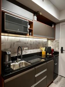 a kitchen with a sink and a microwave at Studio 201 SP Moema Super Equipado in Sao Paulo