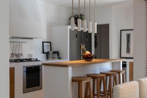 a kitchen with a island with bar stools at Casa Prasoul Villa with Heated Pool & Fitness area in Prasiaí