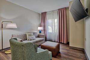 uma sala de estar com um sofá e uma cadeira em Staybridge Suites - Albuquerque Airport, an IHG Hotel em Albuquerque