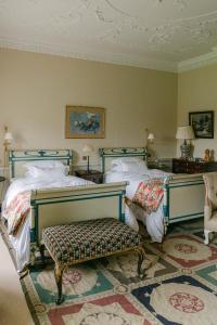a bedroom with two beds and a bench at Summergrove House in Mountmellick