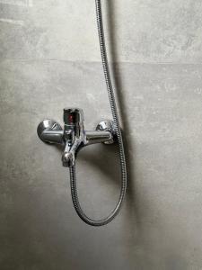 una ducha con una manguera pegada a la pared en Bejart Apartment 4, en Tirana
