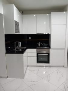 a white kitchen with a sink and a stove at Edifício 2PALMA in Praia