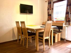 mesa de comedor con 4 sillas y TV en Haus Schröer, en Schruns