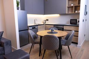a kitchen with a table and chairs in a room at Belgrade Waterfront Cozy Symphony 2 in Sajmište +16 photos