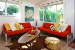un soggiorno con 2 divani rossi e un tavolo di #StayinMyDistrict Modern Mid-Century Retreat a Beaverton