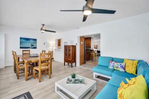 uma sala de estar com um sofá azul e uma mesa em Beach Daze - Summer Sale! Southern Facing Pool, Walk To The Beach - No Ian Damage! em Naples