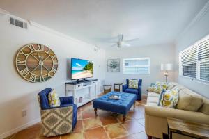 a living room with a couch and a tv at FALL SPECIAL! Seas The Day - This one has it all - Walk to Vanderbilt beach! in Naples