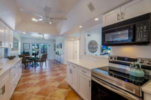 a kitchen with white cabinets and a stove top oven at FALL SPECIAL! Seas The Day - This one has it all - Walk to Vanderbilt beach! in Naples