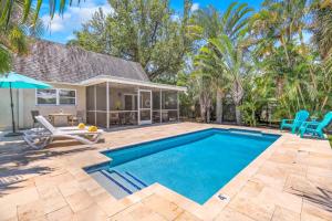 a swimming pool with a patio and a house at FALL SPECIAL! Seas The Day - This one has it all - Walk to Vanderbilt beach! in Naples