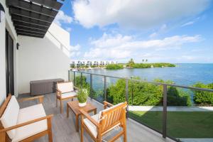 Un balcón con sillas y vistas al océano. en Allure #22 3BR Waterfront, en Red Bay Estate