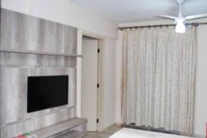 a living room with a flat screen tv and a fireplace at Eldorado Thermas Park frente ao parque aquático in Caldas Novas