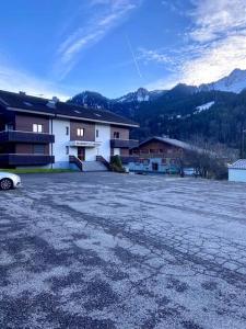 an empty parking lot in front of a building at Appartement neuf à 400 m des remontées avec Sauna in La Chapelle-dʼAbondance
