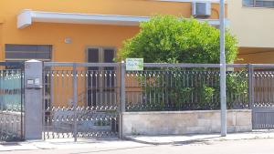 a fence in front of a house with a building at Ladybianca apartment & rooms in Lecce