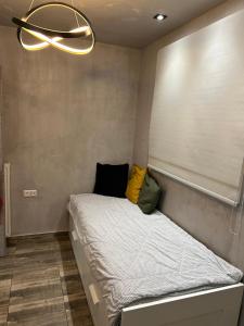a bed with two pillows on it in a room at Overwave Apartment in Kavála