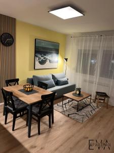 een woonkamer met een bank en een tafel bij Apartman EVA - Dugo Selo / Zagreb in Dugo Selo