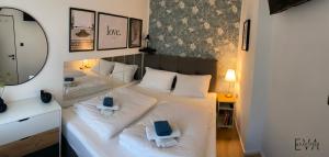 a bedroom with a large white bed with a mirror at Apartman EVA - Dugo Selo / Zagreb in Dugo Selo