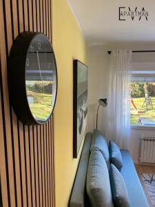 a living room with a blue couch and a mirror at Apartman EVA - Dugo Selo / Zagreb in Dugo Selo