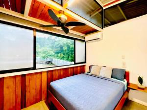 a bedroom with a bed with a ceiling fan and a window at Villas Paraiso, Junquillal, Santa Cruz Desconectate en el Paraiso in Paraíso